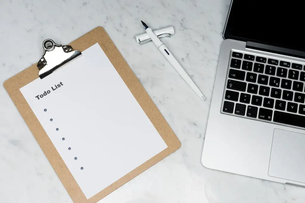 Woman writing a to-do list on a notebook for daily planning using Eisenhower Matrix